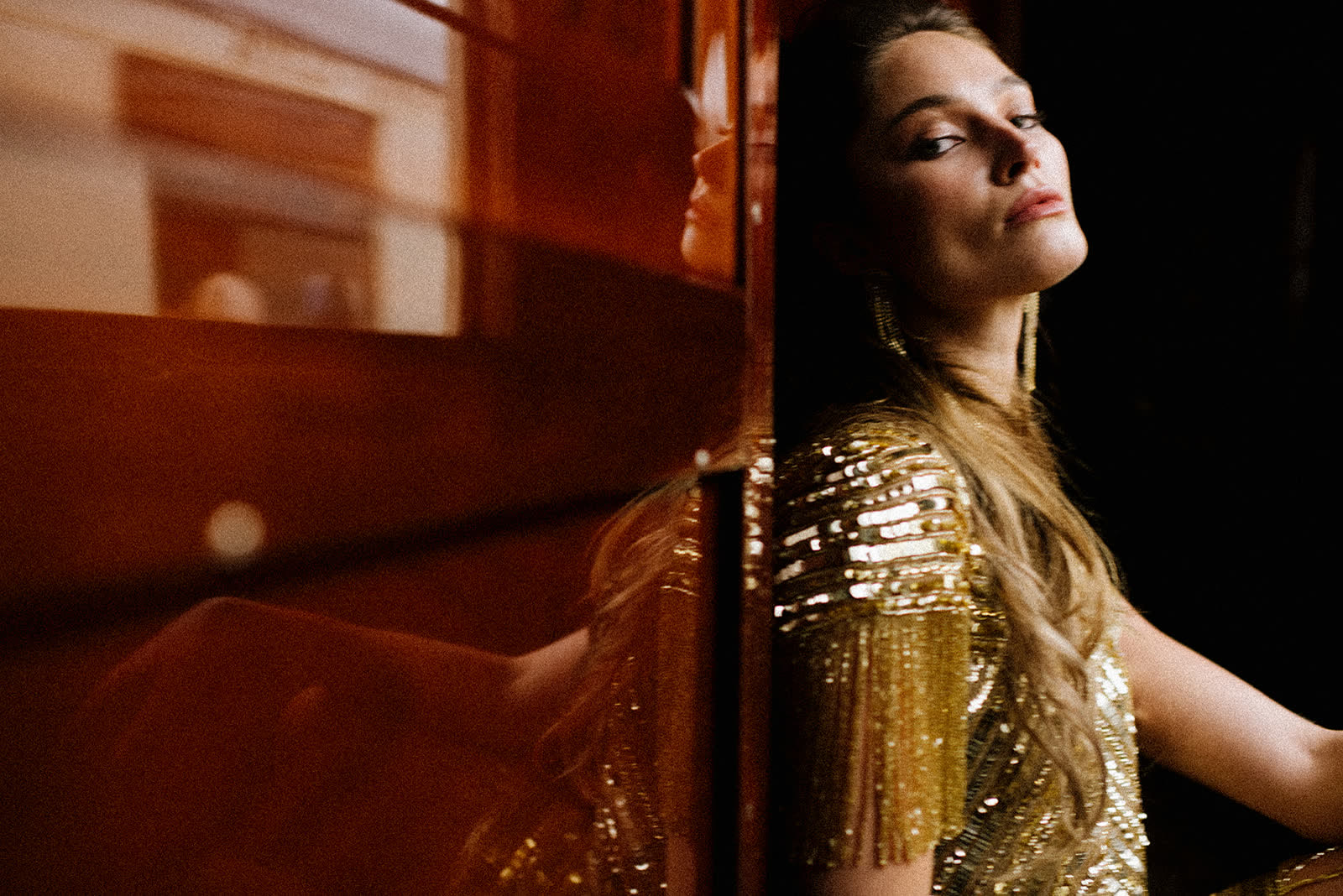Bride in gold sequins reflected in lacquered wood